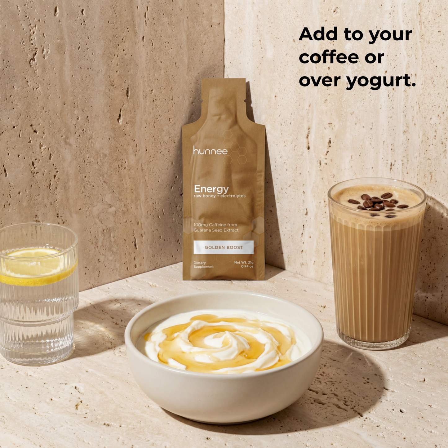 Hunnée Energy package with a bowl of yogurt, glass of water, and glass of coffee on a stone surface.