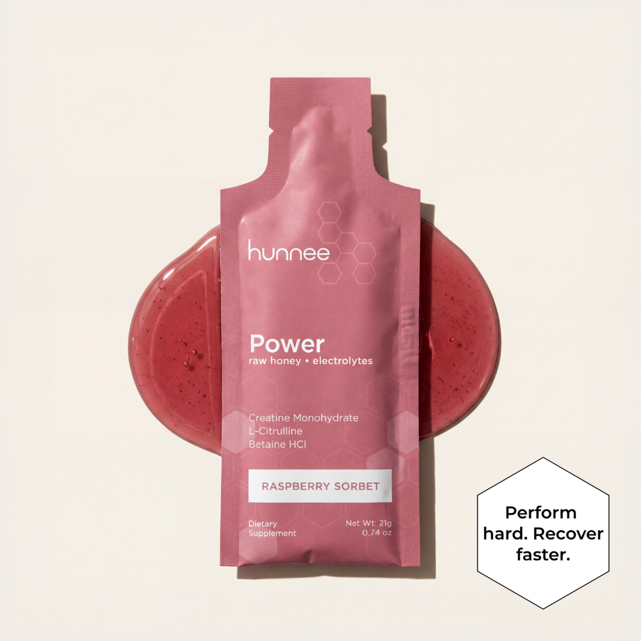 Pink hunnee Power supplement packet with raspberry sorbet flavor on a beige background